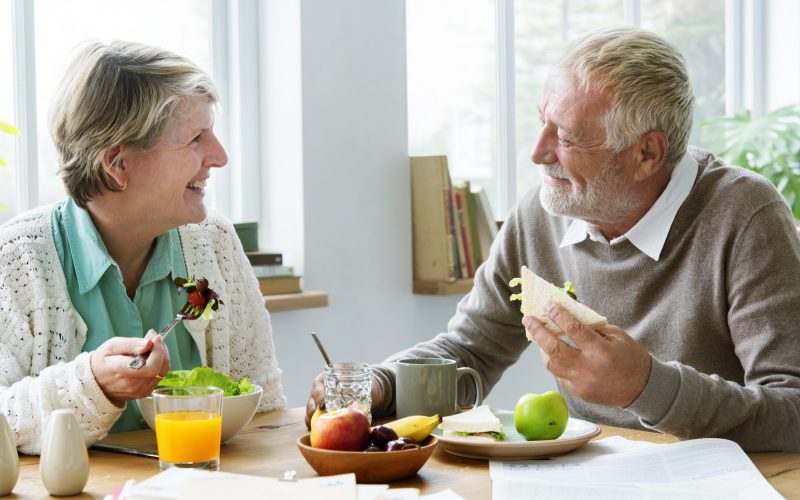 Pensioner couple enjoying a meals on wheels delivery